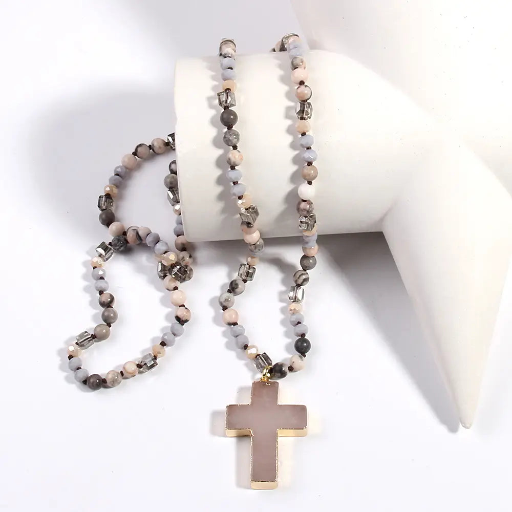A long bohemian natural stone and glass beaded necklace featuring mixed gray and beige stone beads with clear crystal accents and a cross pendant.