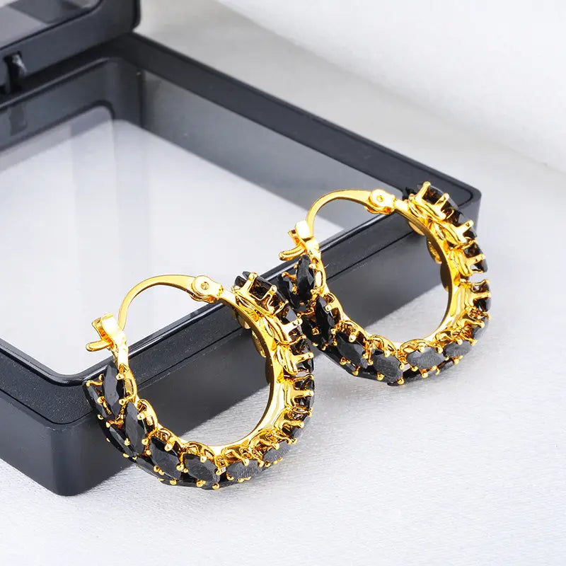 Pendientes de aro con baño de oro de 18k, adornados con piedras de zirconia negra en forma de marquise, facetadas.