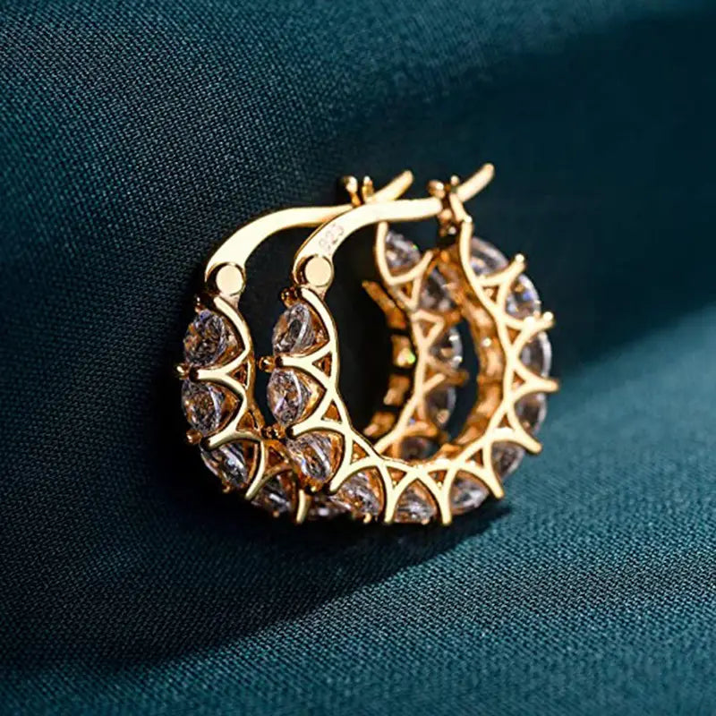 Gold-toned geometric u-shaped hoop earrings adorned with sparkling clear zircon crystals in an intricate lattice pattern.
