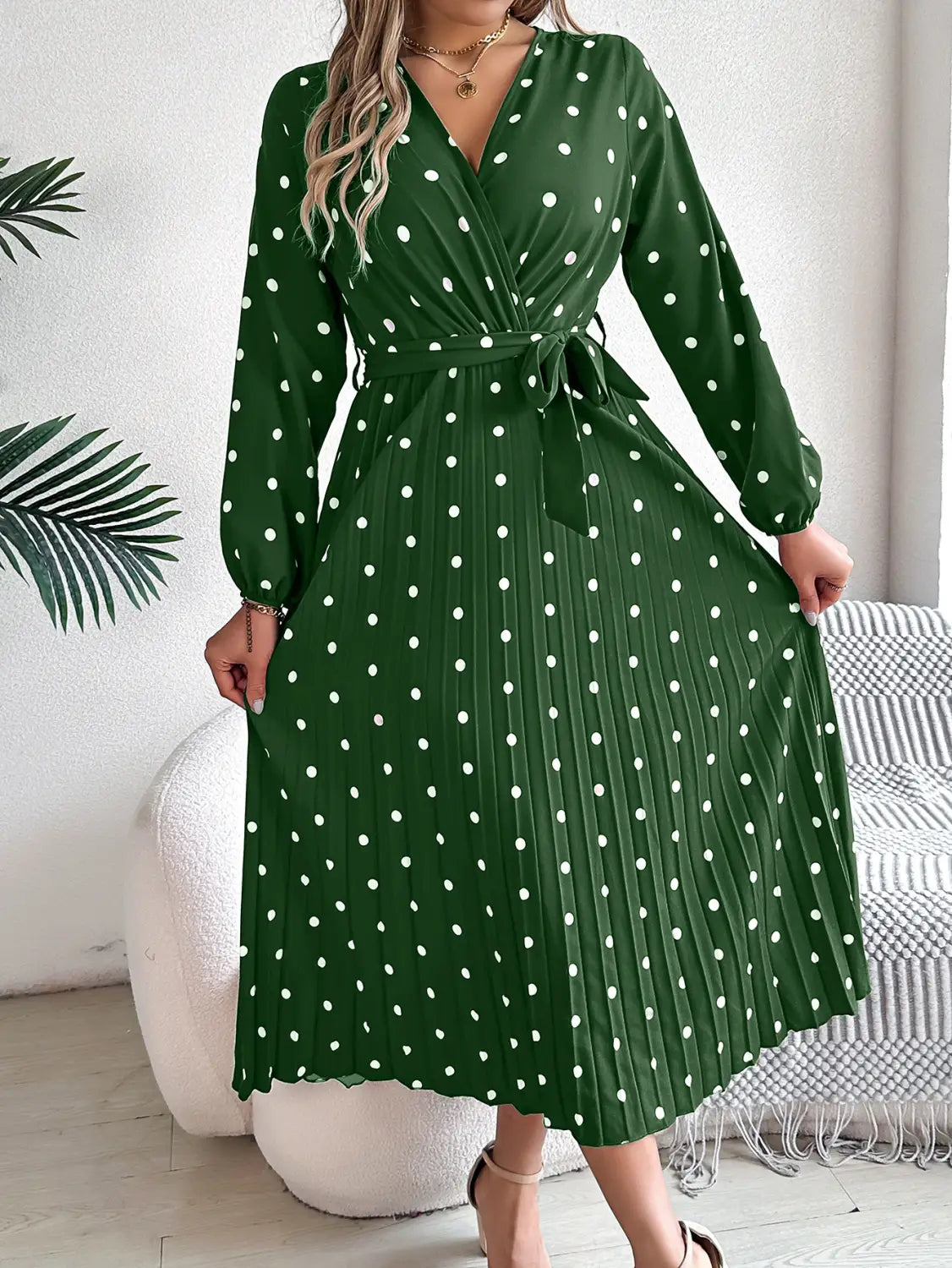 A green polka dot midi dress with long sleeves and a pleated skirt showcasing the front design of the polka dot pleated v neck long sleeve maxi dress.