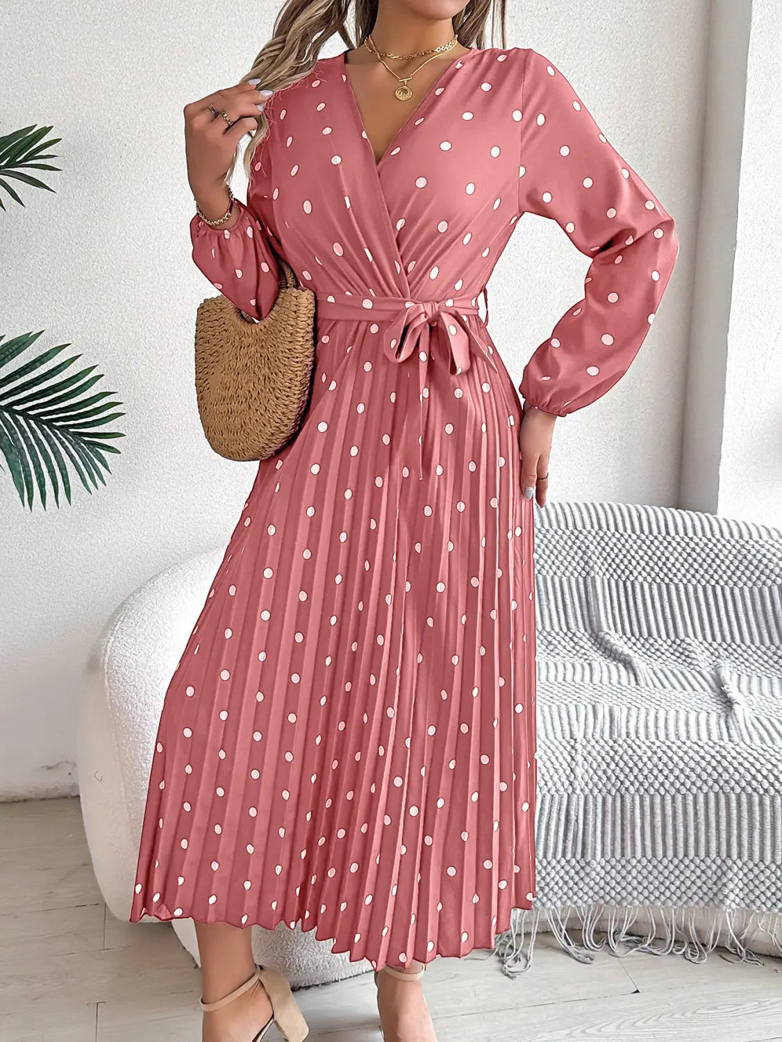 a pink polka-dot midi dress with long sleeves and a pleated skirt featuring a v neck suitable for formal occasions