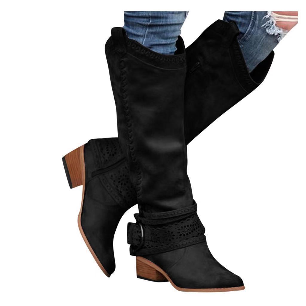 Black suede knee-high women’s suede knight boots with a low block heel and decorative perforated detailing around the ankle buckle strap.