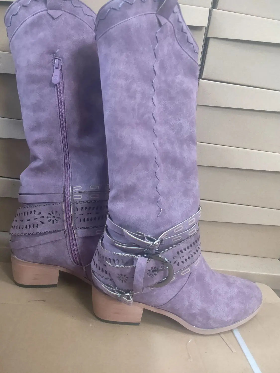 Purple suede women’s knight cowboy boots featuring decorative stitching, metallic buckle straps, and a low block heel.