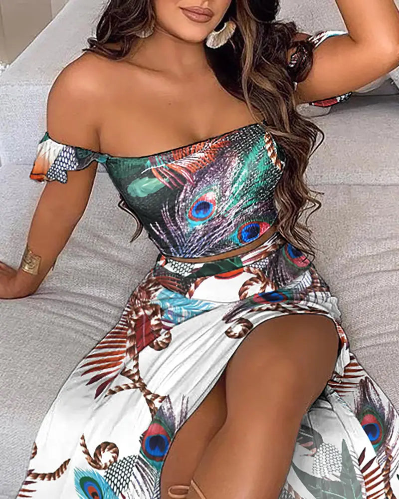 A vibrant bohemian off-shoulder high slit two-piece maxi dress with a bold peacock feather print in shades of green blue and brown on a white base fabric.