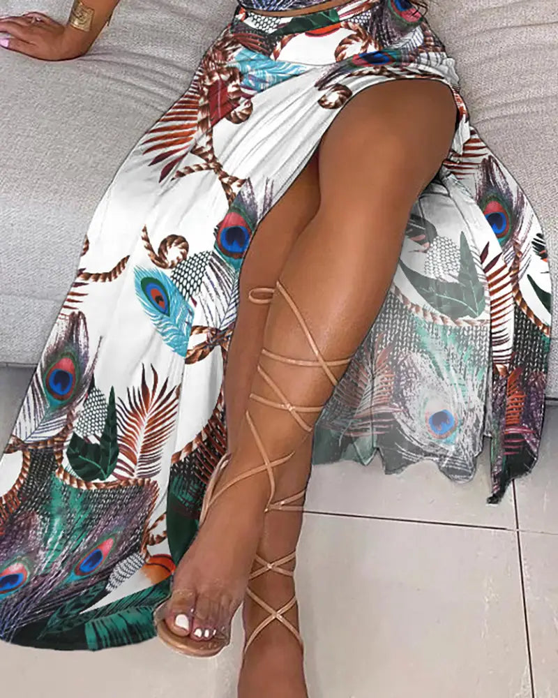 a flowing maxi skirt with a vibrant peacock feather print in shades of blue green brown and white as part of a bohemian off-shoulder high slit two-piece maxi dress