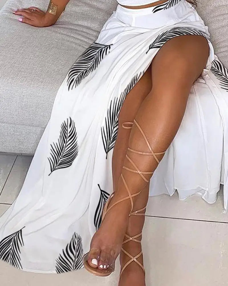 white maxi skirt with black palm leaf print and high slit featured in a bohemian off-shoulder two-piece maxi dress