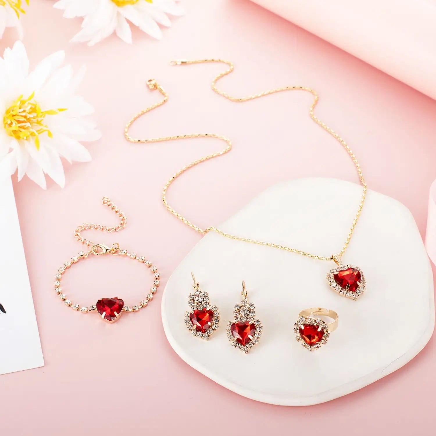 Gold heart-shaped 4 piece rhinestone jewelry set featuring red gemstones and sparkling crystals in a matching design.