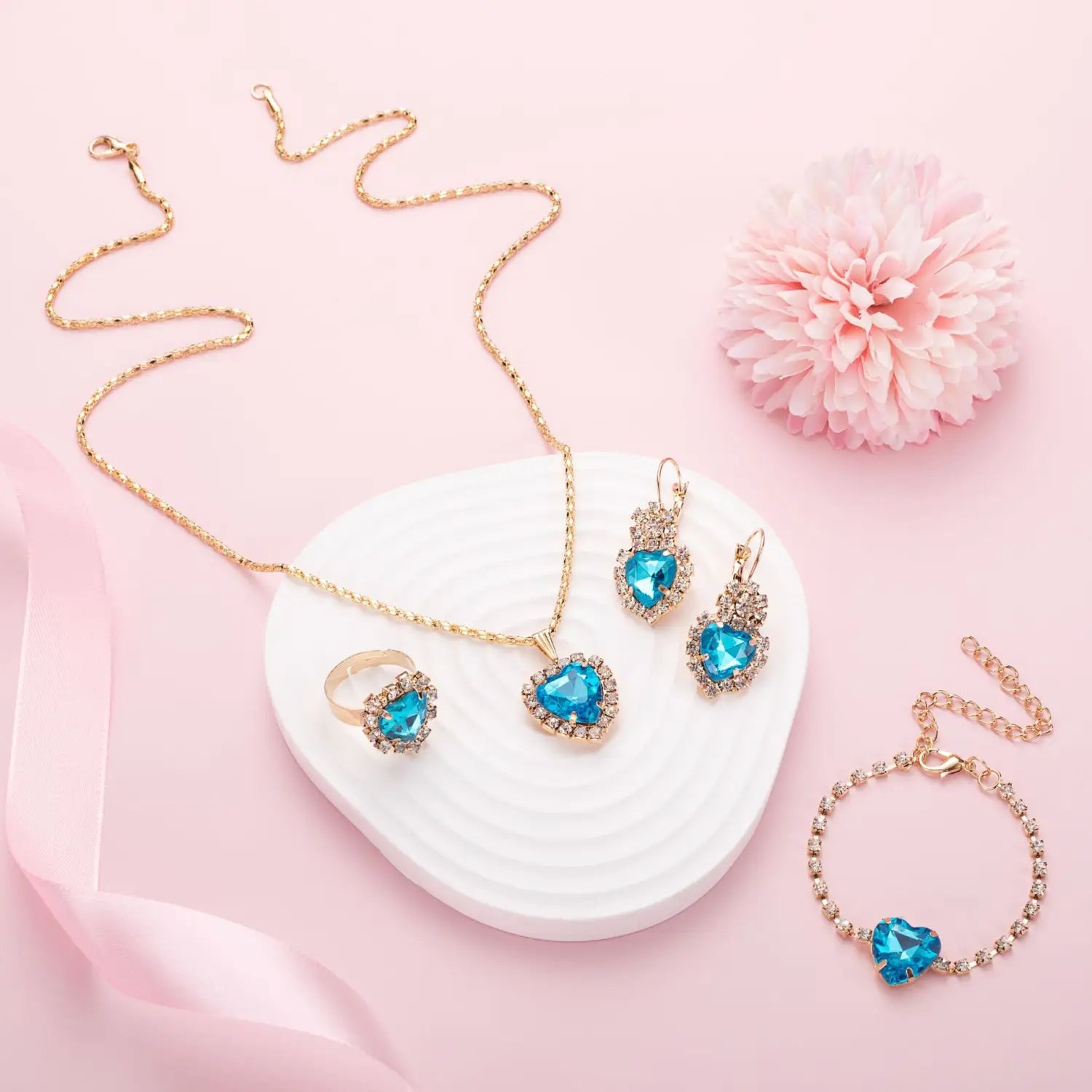 Gold-toned four piece heart rhinestone jewelry set featuring blue heart-shaped gemstones encrusted with clear crystals.