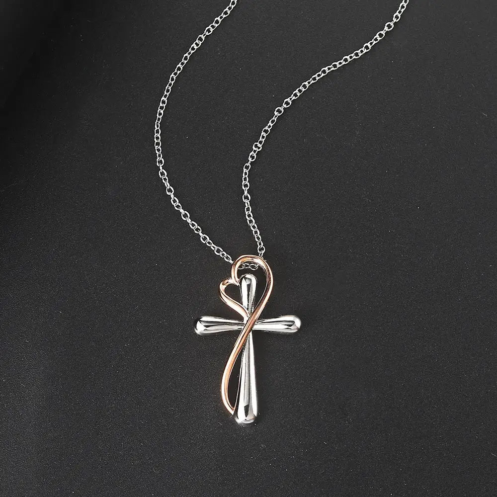 A two tone silver and rose gold heart infinity cross necklace pendant featuring a heart shaped design suspended on an elegant chain.