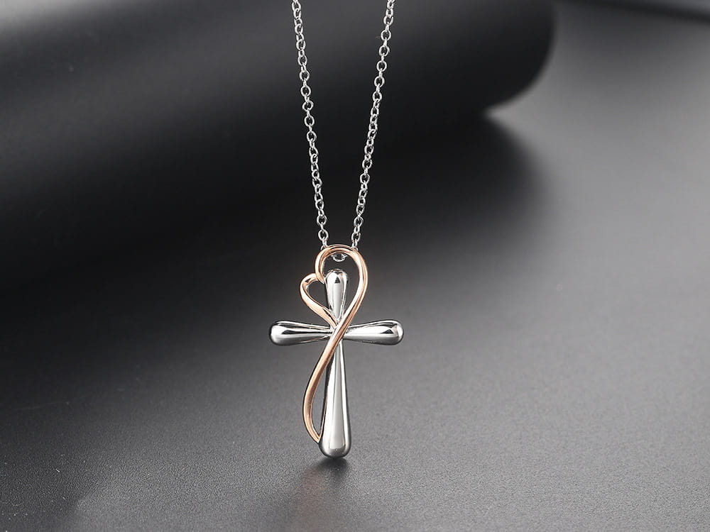 A two tone silver and rose gold heart infinity cross necklace pendant with a delicate chain.