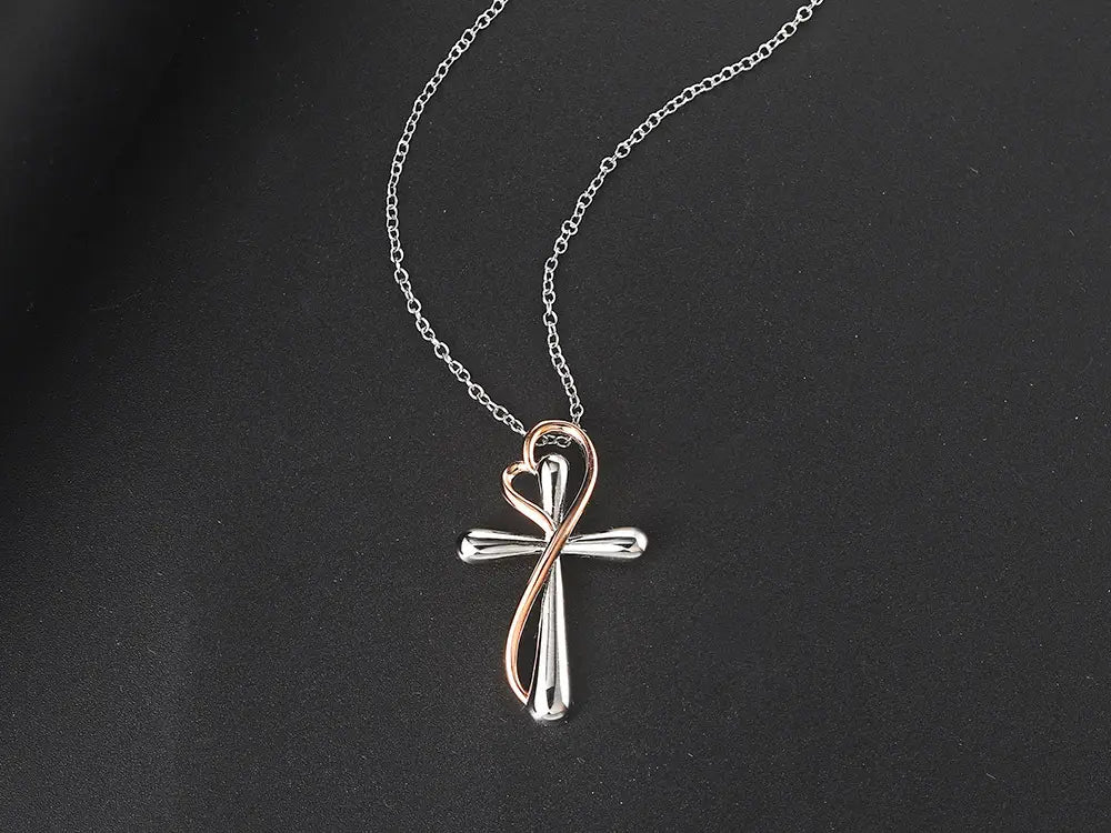 A two tone silver and rose gold heart infinity cross necklace pendant with a heart shaped design suspended on an elegant chain.