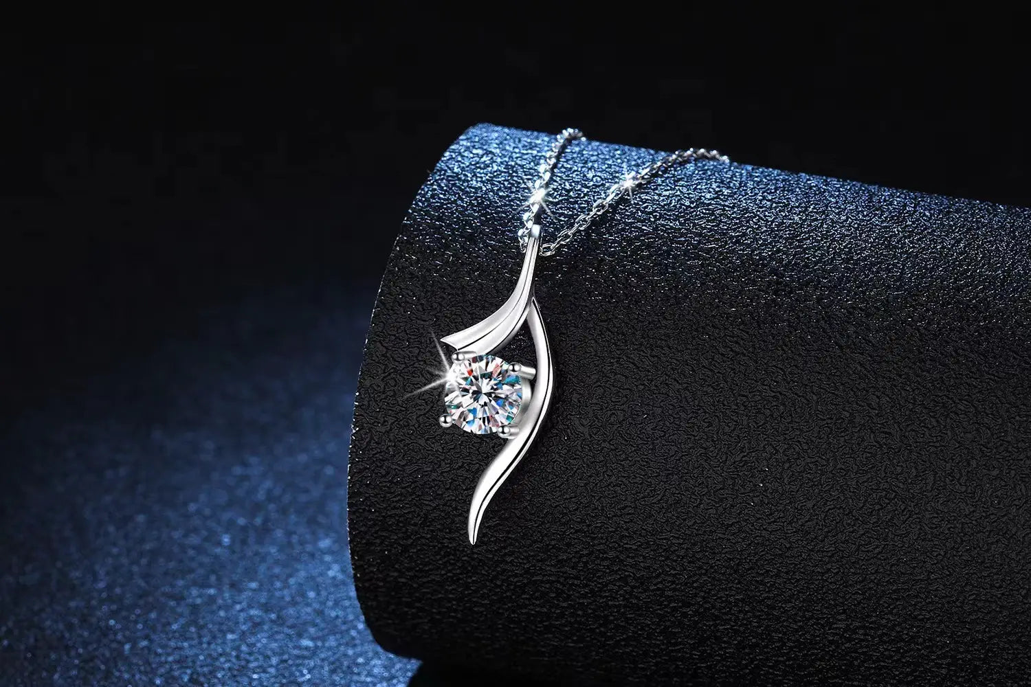 925 sterling silver twisted moissanite solitaire necklace featuring a silver pendant with a single round-cut diamond set in an elegant flowing leaf-shaped design.