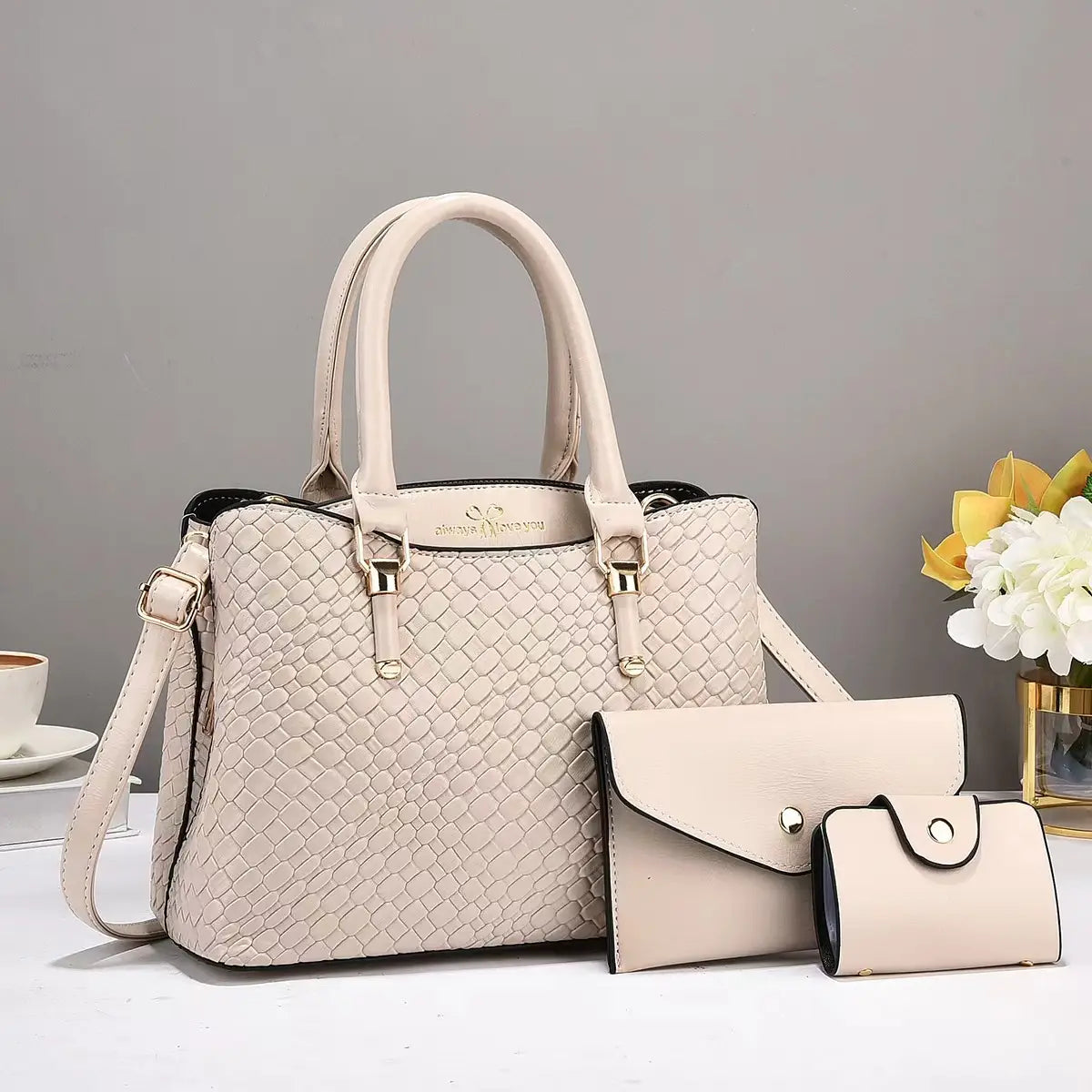 Beige woven leather three piece handbag set featuring a handbag, matching clutch, and wallet with gold-tone hardware.