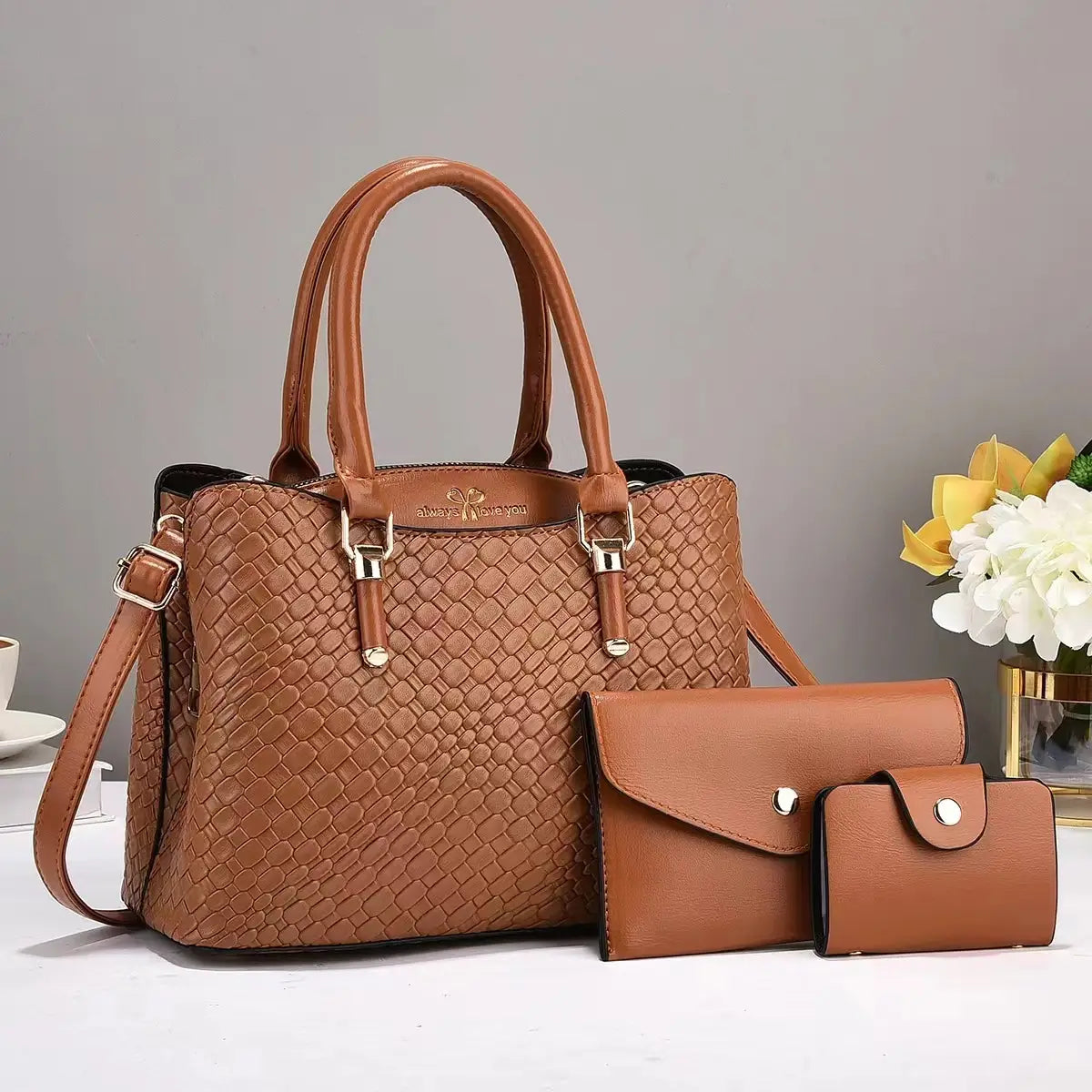 Brown woven leather handbag set featuring gold-tone hardware with matching clutch and wallet in a three piece design.