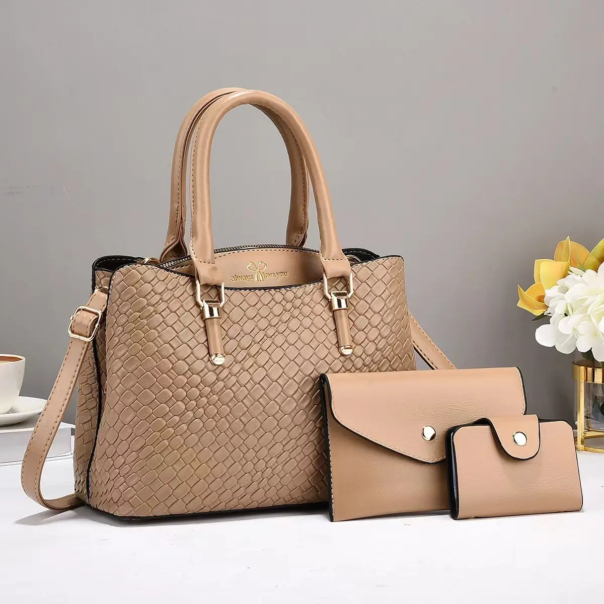 Beige woven leather three piece handbag set featuring a handbag, matching clutch, and wallet with gold hardware.