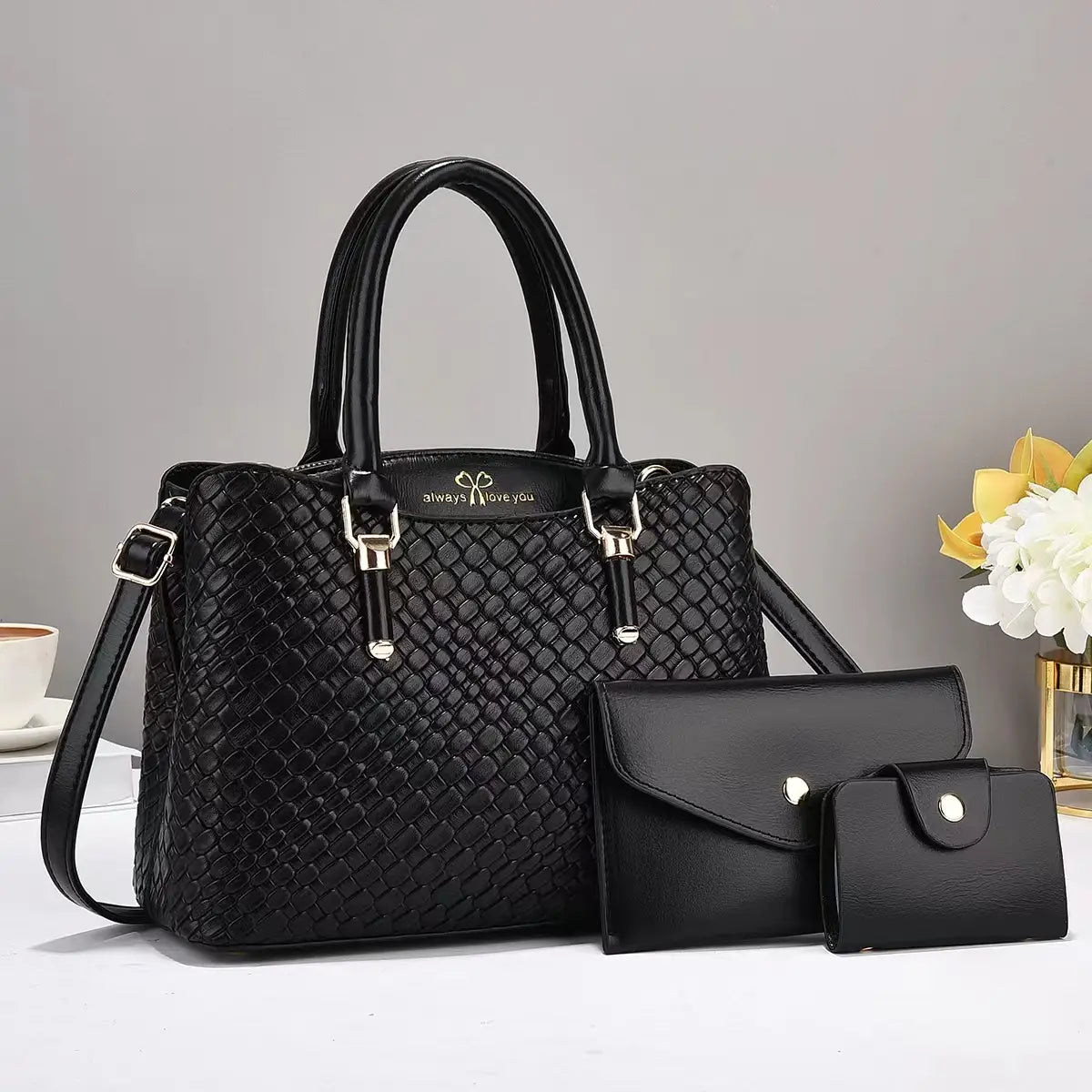 Black woven leather handbag with silver tone hardware and always love you logo on the front from the woven leather three piece handbag set with gold hardware