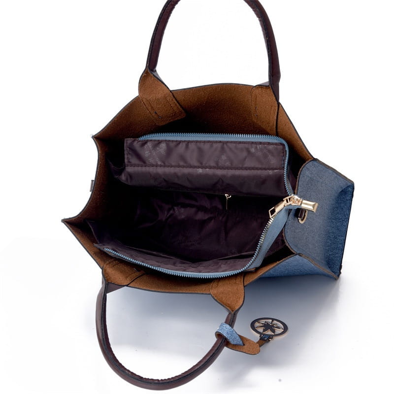 Denim and leather three piece multi compartment handbag set featuring a brown and blue two tone tote bag with leather handles and a decorative compass charm.