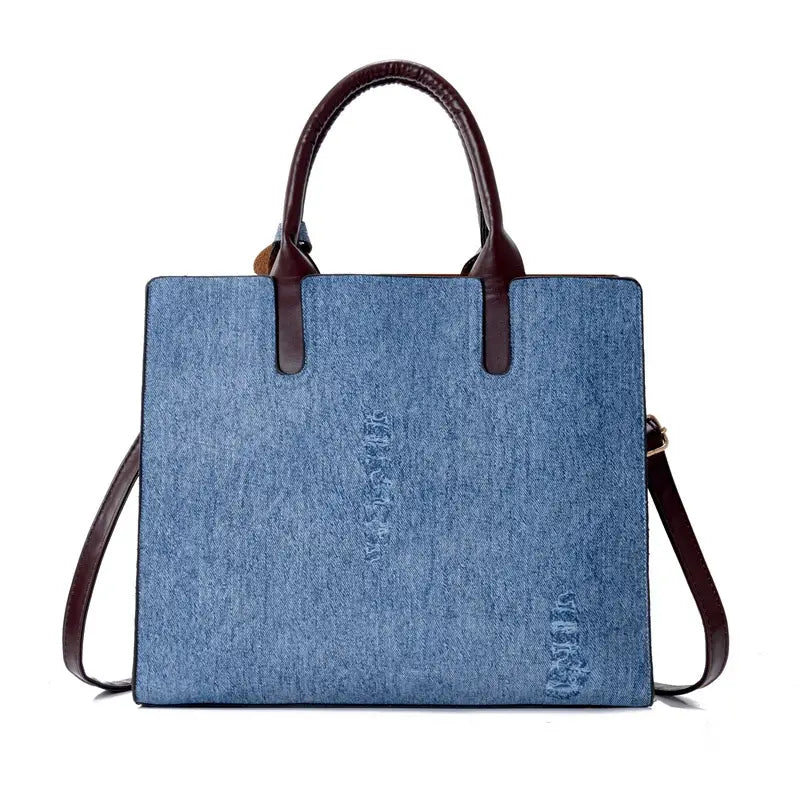 Blue denim tote bag with brown leather handles and shoulder strap from the denim and leather three piece multi compartment handbag set.
