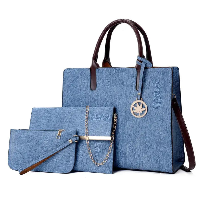 Blue denim and leather three piece multi compartment handbag set with brown leather handles and a silver maple leaf charm.