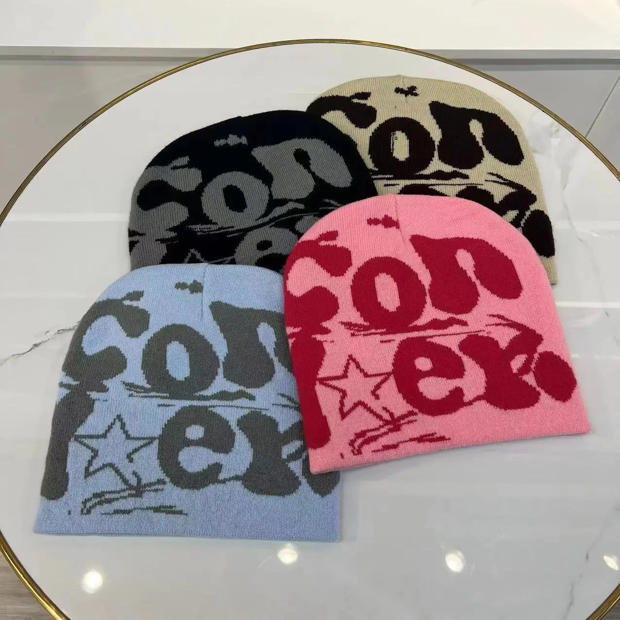Pink knitted letter jacquard beanie warm winter hat featuring bold red con lettering and a star design.