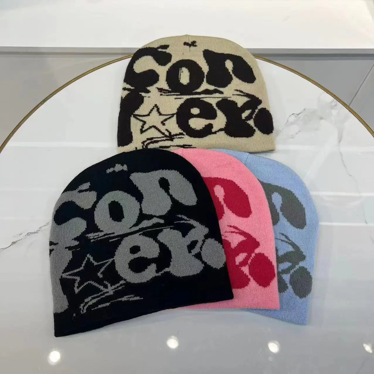 Beige black pink and light blue knitted letter jacquard beanies feature bold converse lettering with star accents in matching or contrasting colors for warm winter use.