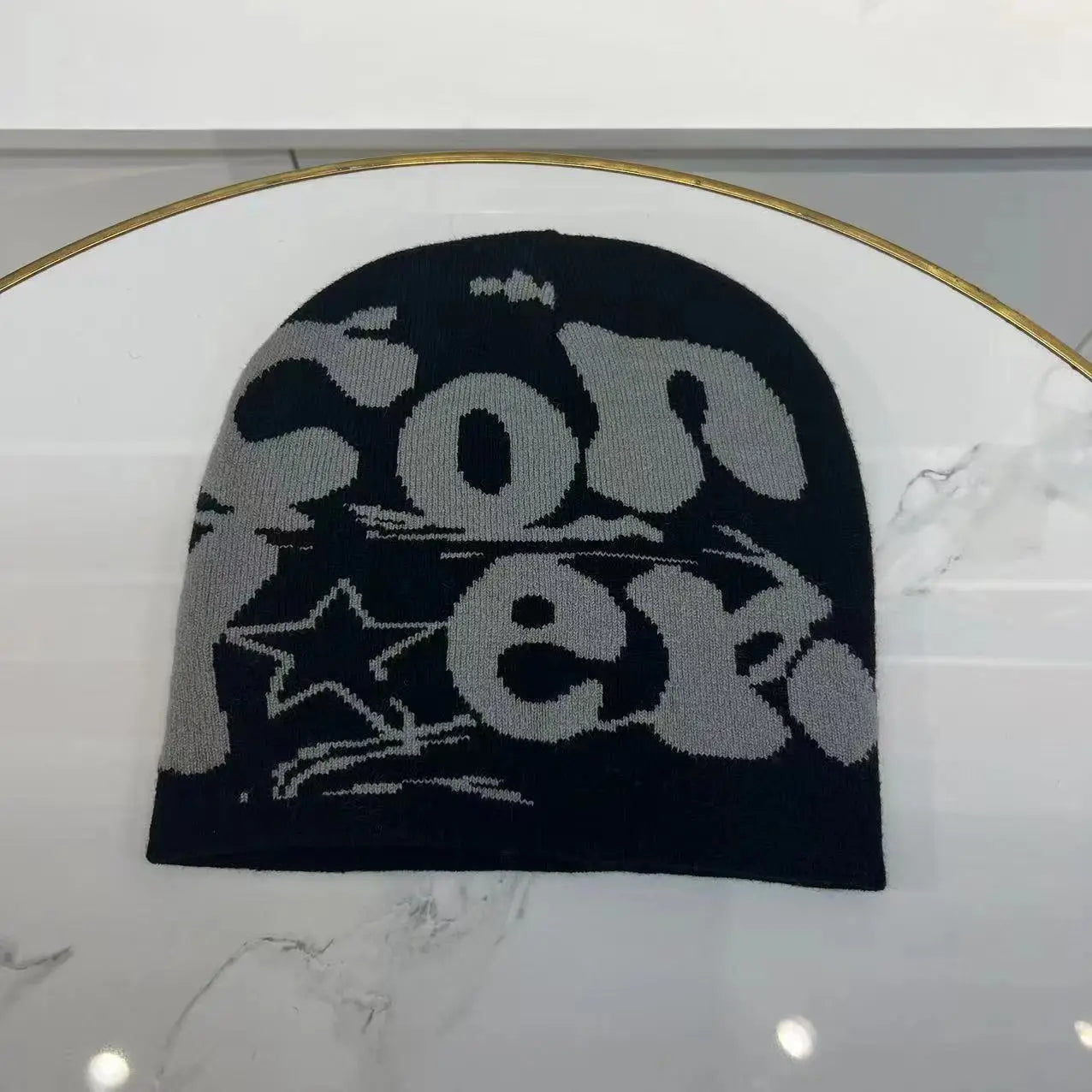 Black knit beanie with gray converse lettering and star graphic featuring knitted letter jacquard design for a warm winter hat.