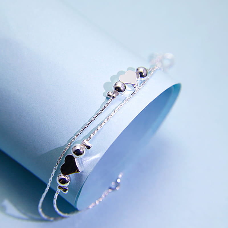 Delicate Korean double layer silver heart bead bracelet with alternating heart-shaped charms and small spherical beads on a fine silver chain.