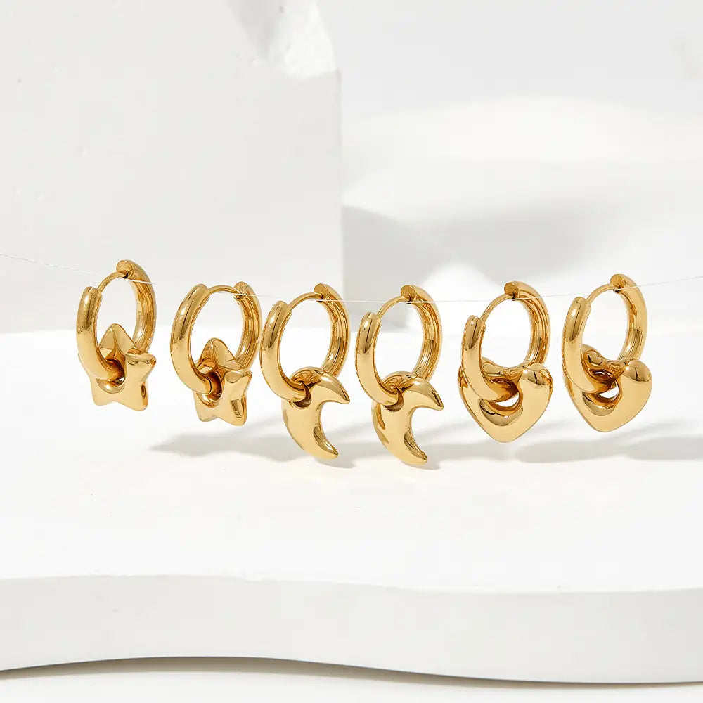 Polished stainless steel gold-toned hoop earrings with dangling star and crescent moon geometric charms.