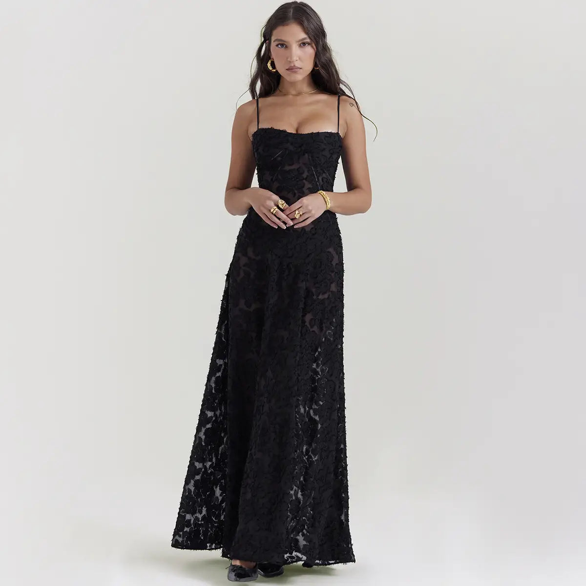 Robe longue maxi élégante en dentelle noire brodée, présentant des motifs floraux délicats et de fines bretelles spaghetti.