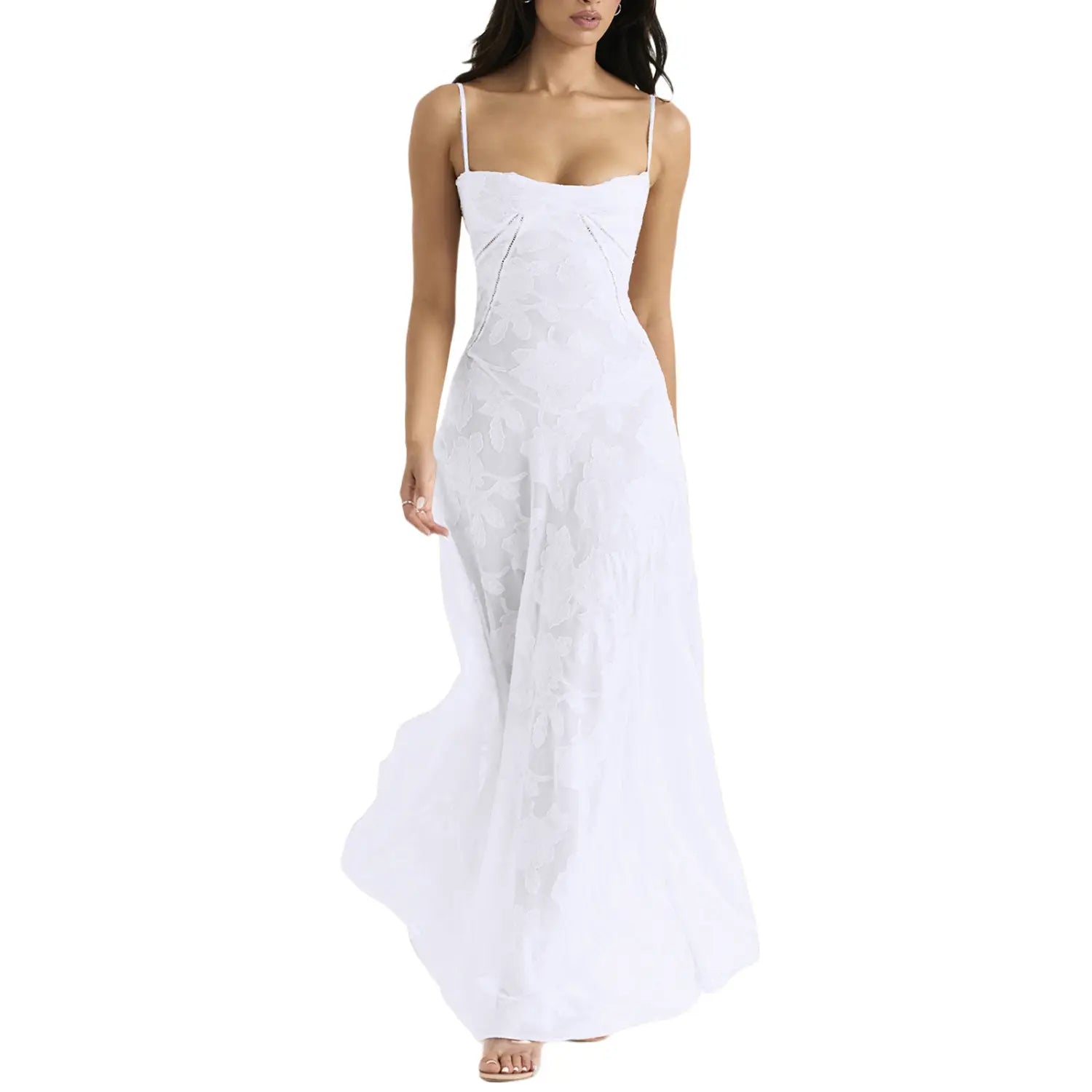Robe longue maxi élégante en dentelle brodée blanche à bretelles spaghetti, avec un tissu léger et fluide et des détails texturés subtils le long du corsage.