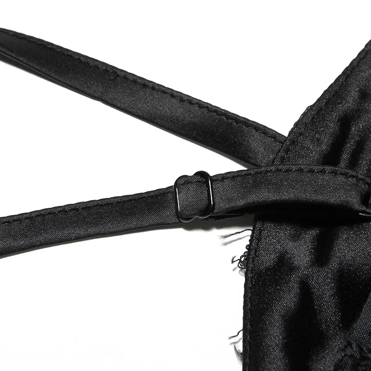 Sangle noire en satin avec une boucle métallique à l’arrière d’une robe longue maxi élégante à bretelles spaghetti en dentelle brodée.