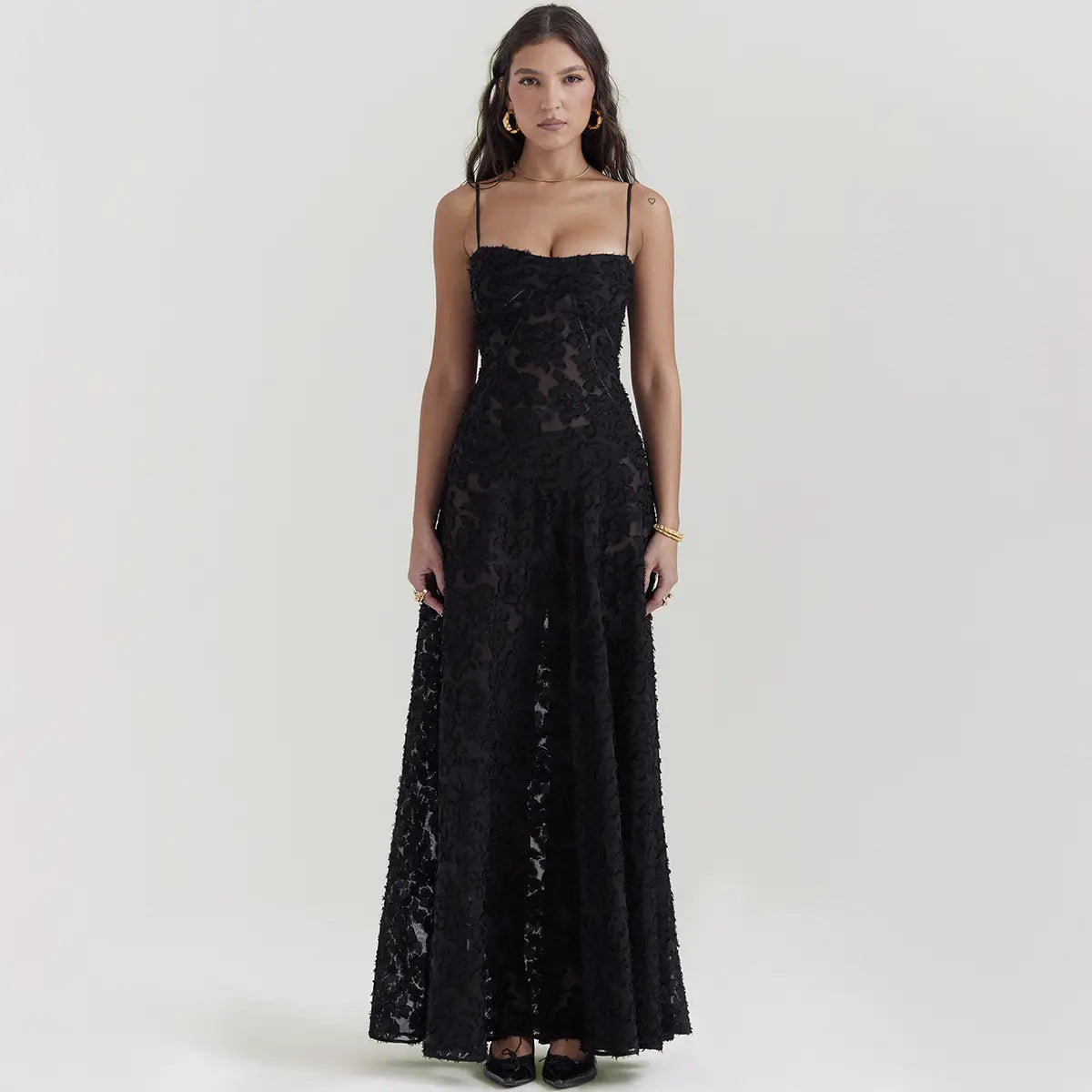Robe longue maxi élégante en dentelle noire brodée, avec des motifs floraux délicats et de fines bretelles spaghetti.