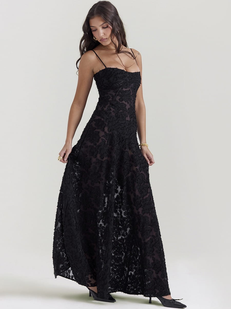 Robe longue maxi en dentelle noire brodée, avec des motifs floraux délicats et de fines bretelles spaghetti.