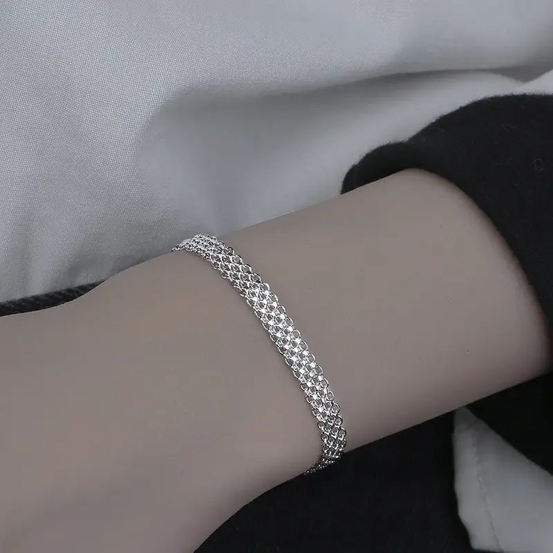 A multi-layer silver mesh heart clasp bracelet featuring a delicate silver mesh with a fine interwoven chain design.