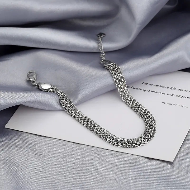 Multi-layer silver mesh heart clasp bracelet featuring a silver-toned multi-strand mesh design with a sleek heart-shaped clasp.