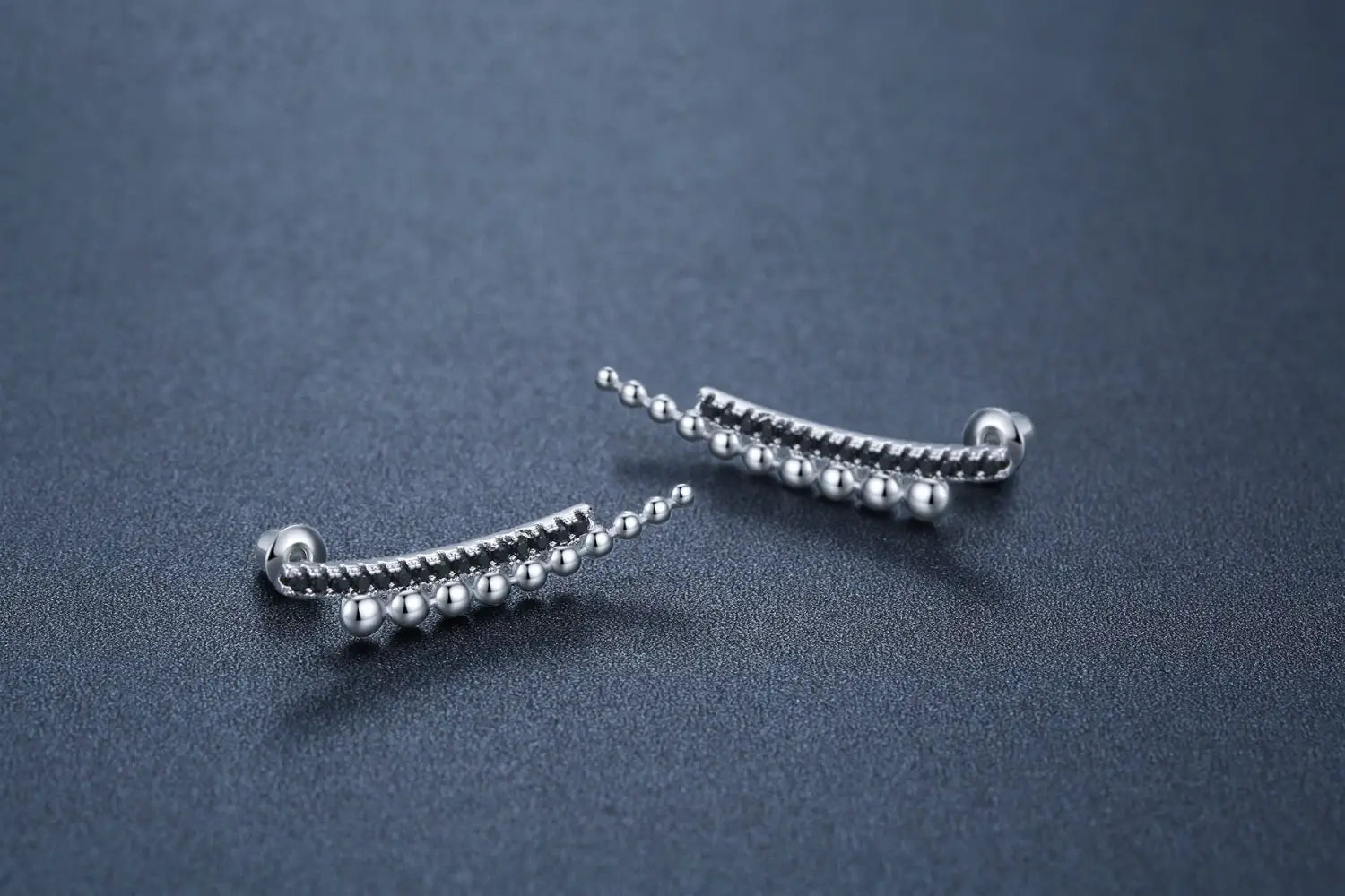 silver curved ear cuffs with beaded and textured detailing complement black zircon and silver beaded cascading drop earrings in elegant jewelry collection