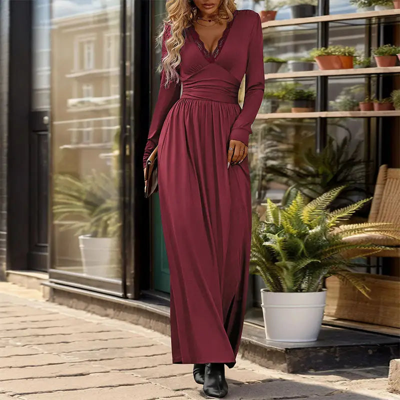 a flowing maroon long-sleeved maxi dress with a v-neckline and subtle ruching at the waist suitable for formal occasions