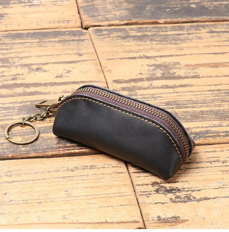 Black leather premium cowhide multi-functional key and coin pouch with a brown zipper and brass-colored metal ring.