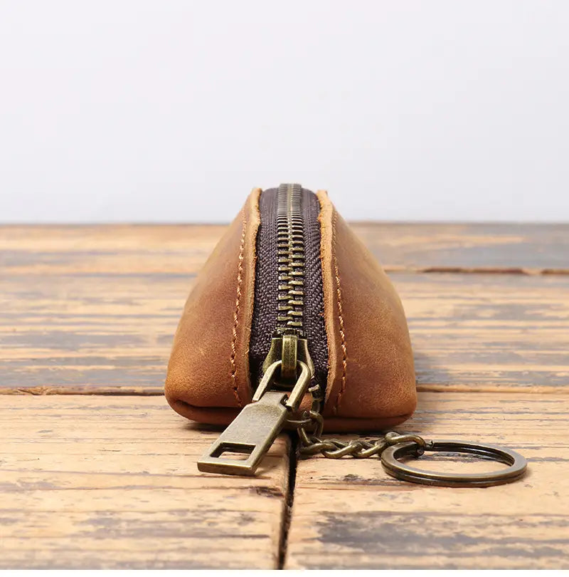 Premium cowhide leather multi-functional key and coin pouch in tan with a dark zipper and brass hardware.