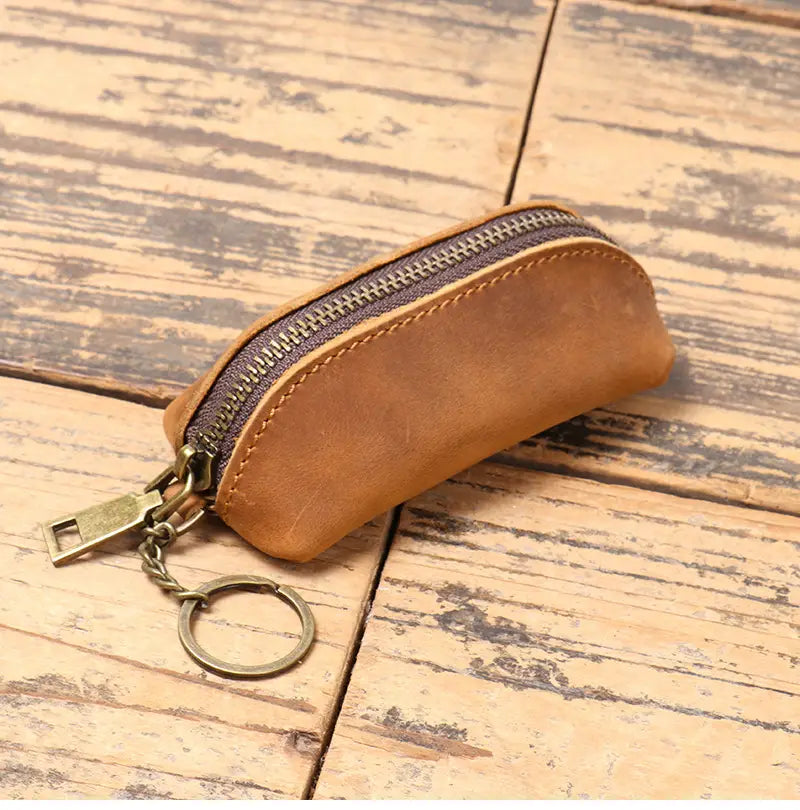 Premium cowhide leather multi-functional key and coin pouch in tan leather with dark zipper and brass hardware.