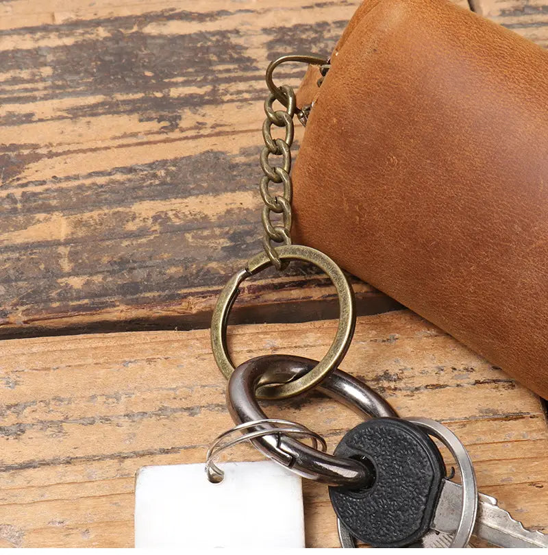 Brown leather keychain with brass chain and metal rings attached to keys from premium cowhide leather multi-functional key and coin pouch.