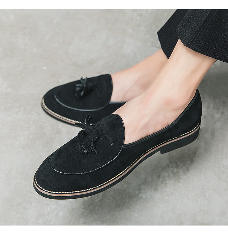 Men’s black suede tassel loafers made of matte cowhide with decorative tassels and contrasting stitching.