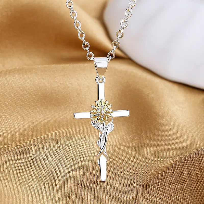 Two-tone silver and gold sunflower cross pendant necklace featuring gold accents and sparkling stones.