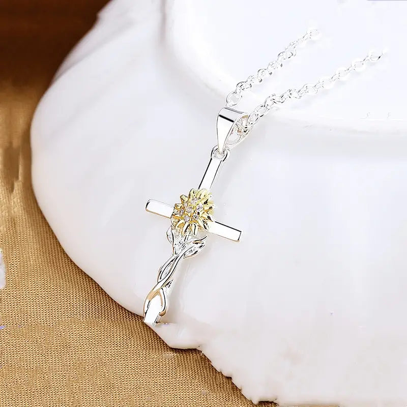 Two-tone silver and gold sunflower cross pendant necklace featuring a silver cross and a gold-toned sunflower on a delicate chain.