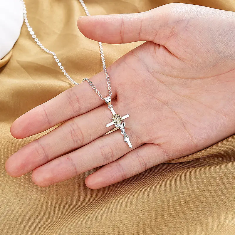 silver crucifix pendant with detailed figure of Christ on the cross suspended from a delicate chain in a two-tone silver and gold sunflower cross pendant necklace
