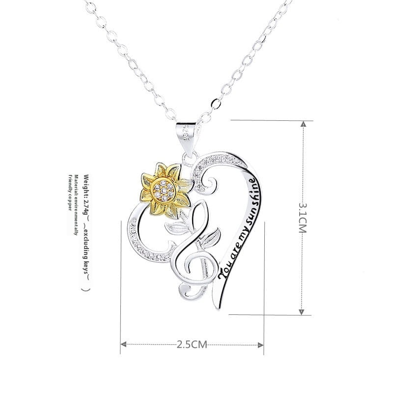 Silver heart-shaped pendant necklace with a gold sunflower charm engraved with you are my sunshine text and clear gemstones along the edges in the you are my sunshine sunflower heart pendant necklace product.