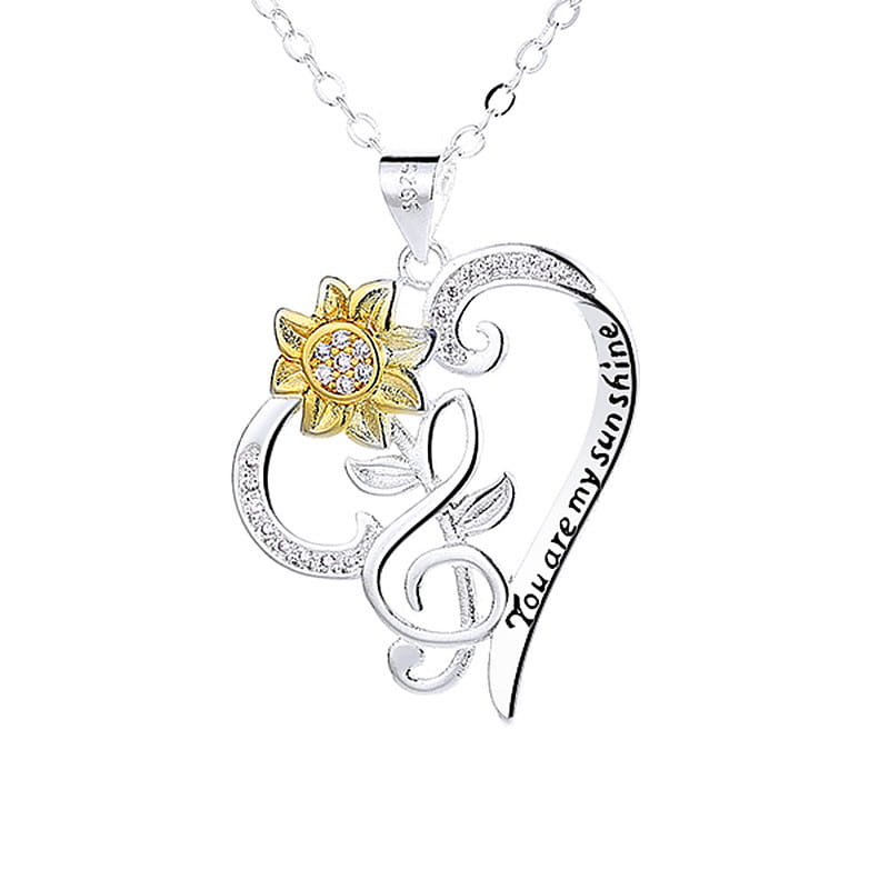 Silver heart-shaped pendant necklace featuring a gold sunflower and engraved you are my sunshine with clear gemstones along the edges.