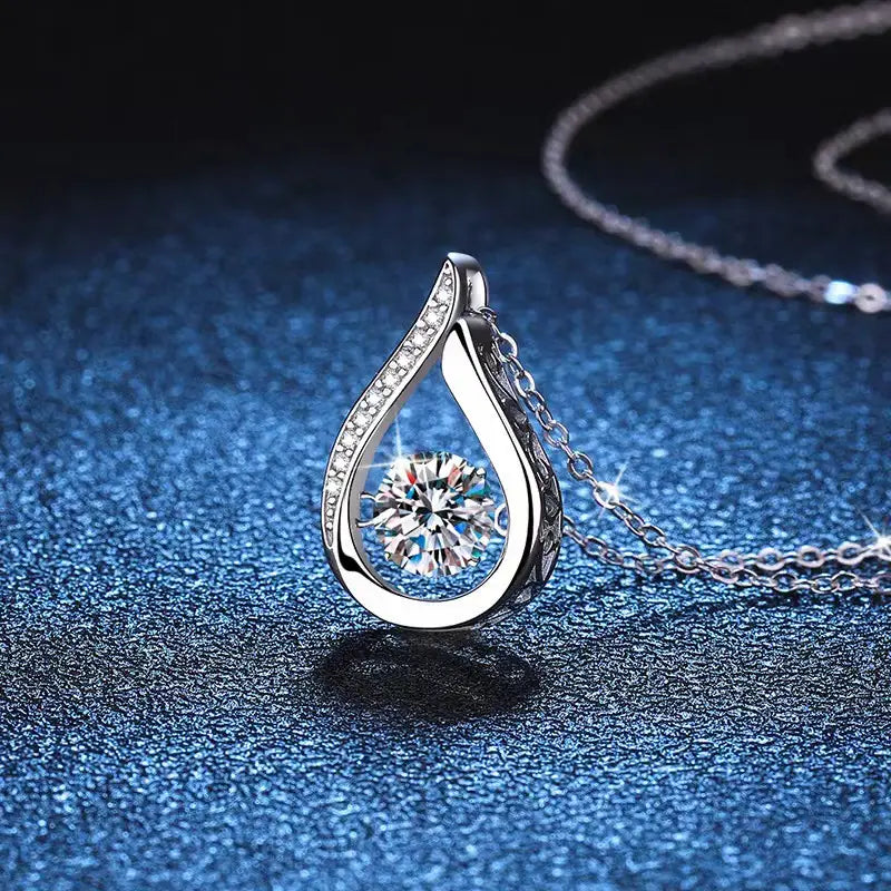 Silver teardrop crystal pave diamond pendant necklace featuring a central round-cut clear gemstone surrounded by smaller diamonds along curved edges.