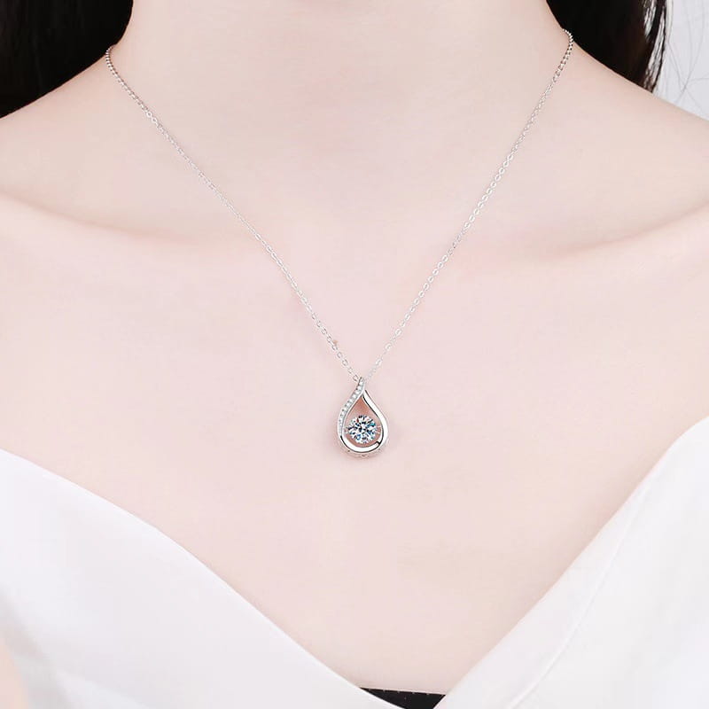 A delicate silver teardrop crystal pave pendant necklace featuring a central blue gemstone encircled by smaller clear stones.