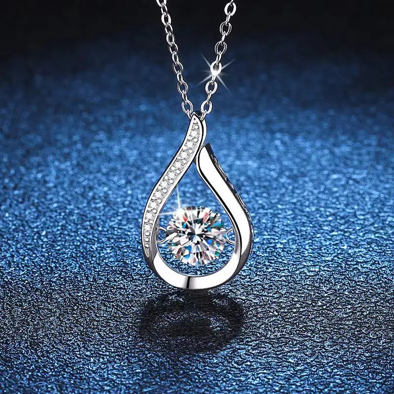 A silver teardrop crystal pave diamond pendant necklace featuring a central round-cut clear gemstone surrounded by smaller sparkling stones along its curved edges.